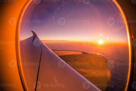 Beautiful sunset sunrise scenic view through the aircraft window with wings. Looking out window ...