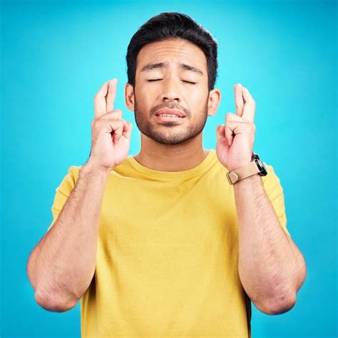 Premium Photo | Hope man and fingers crossed for luck in studio isolated on a blue background ...