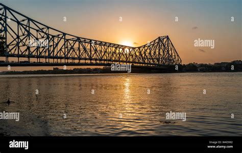 Silhouette of Howrah Bridge at the time of Sunrise. Howrah Bridge is a ...