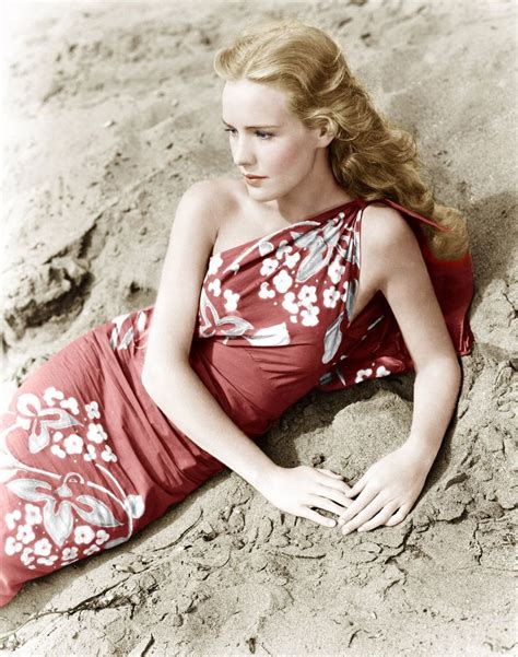 a woman in a red dress laying on the sand