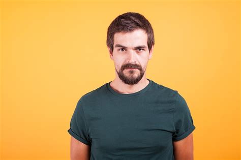 Free Photo | Grumpy stressed worried man on yellow background lookin at ...