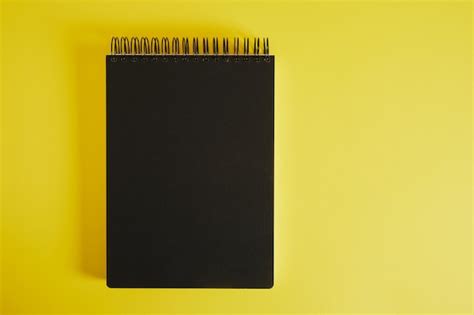 Premium Photo | Black notepad spiral on yellow background mockup