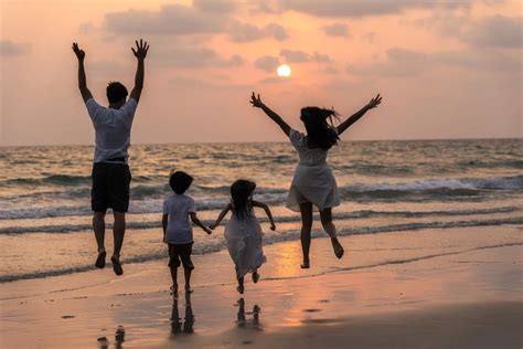 Asian young happy family enjoy vacation on beach in evening. Dad ...