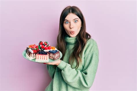 Premium Photo | Young beautiful caucasian girl holding cake slices ...