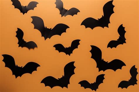 Premium Photo | Halloween black bats on orange background