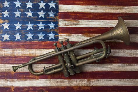 Old trumpet on American flag Photograph by Garry Gay