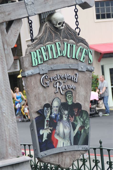 a sign that says beetlejuice's graveyard revale hanging from the side of a fence