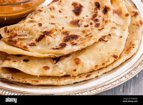 Indian layered Paratha roti kerala porotta with chicken curry on the ...