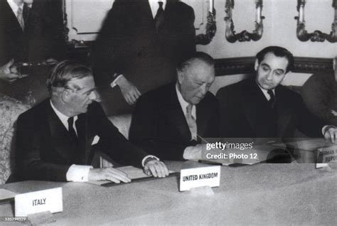 Adenauer, surrounded by Eden and Mendès-France, signs the agreement... News Photo - Getty Images