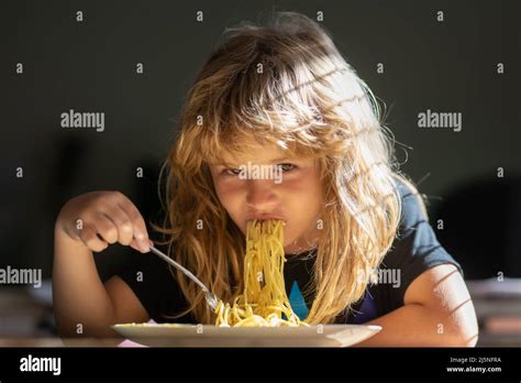 Child eating on blurred background. Hungry little boy eating. Home food ...