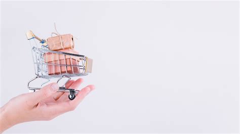 Free Photo | Person holding small grocery cart with gift boxes