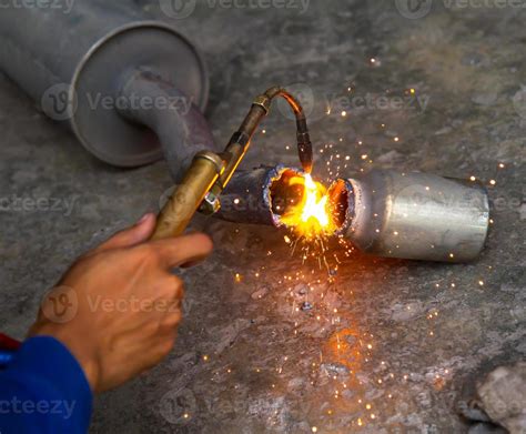 worker welding metal exhaust pipe with sparks 871670 Stock Photo at Vecteezy