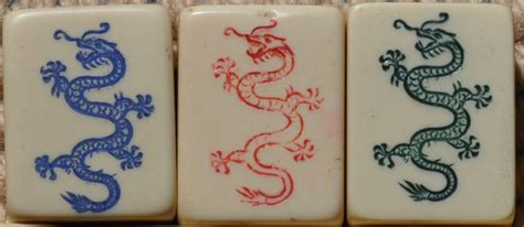 three white and blue tiles with red, green and blue dragon designs on the sides