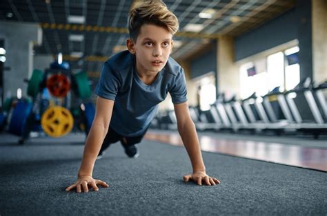 Premium Photo | Boy doing push up exercise in gym, front view. Youngster on training in sport ...