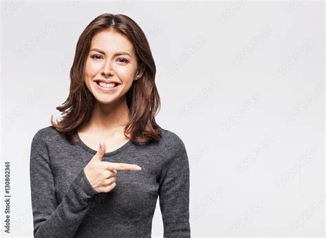 Laughing beautiful girl is pointing to product Stock-Foto | Adobe Stock