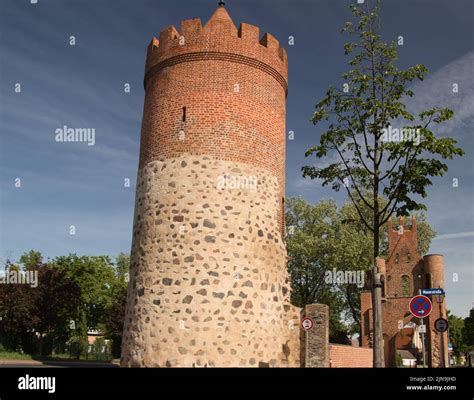 A round brick tower under blue cloudy sky with green trees Stock Photo ...