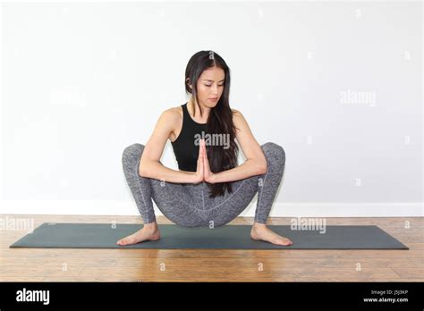 Beautiful woman doing a yoga pose called squat pose, or malasana Stock Photo: 141154266 - Alamy