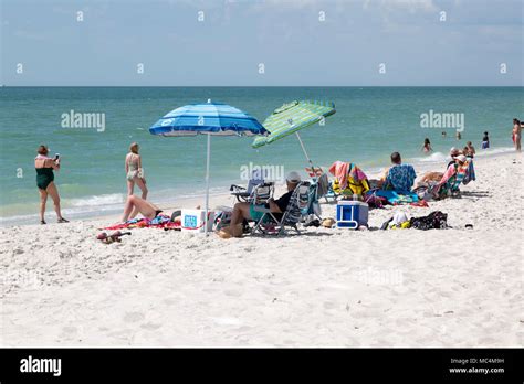 Vacationers in Naples, Florida enjoying beach activities. Sunbathing ...