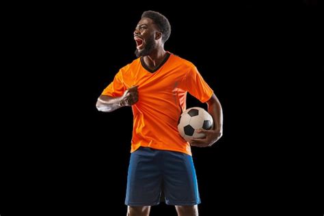 Free Photo | Portrait of young African soccer player posing isolated on black background Concept ...