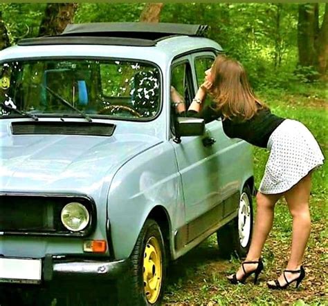 a woman leaning on the door of a small car