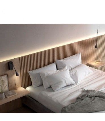 there is a bed with white sheets and pillows on the headboard in this bedroom