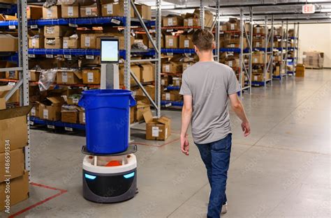 Manager walking with picking Robot in warehouse Stock Photo | Adobe Stock