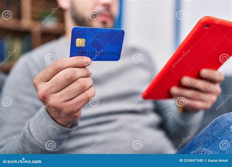 Jeune Homme Latin Utilisant Le Pavé Tactile Et La Carte De Crédit Assis Sur Le Canapé à La ...