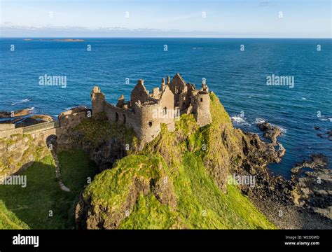 Ruins of medieval Dunluce Castle on a steep cliff. Northern coast of ...