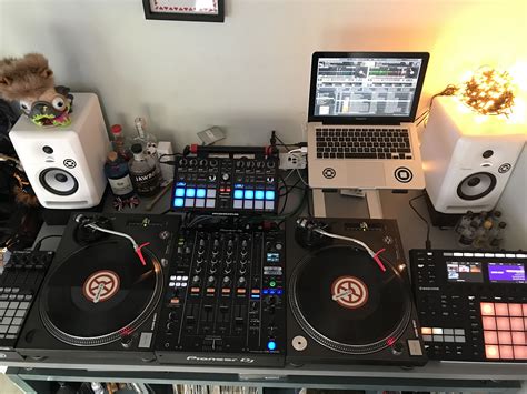 a laptop computer sitting on top of a dj's desk next to two decks