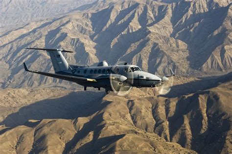 An USAF MC-12 Liberty comms/ELINT aircraft flies over mountains on a reconnaissance mission ...