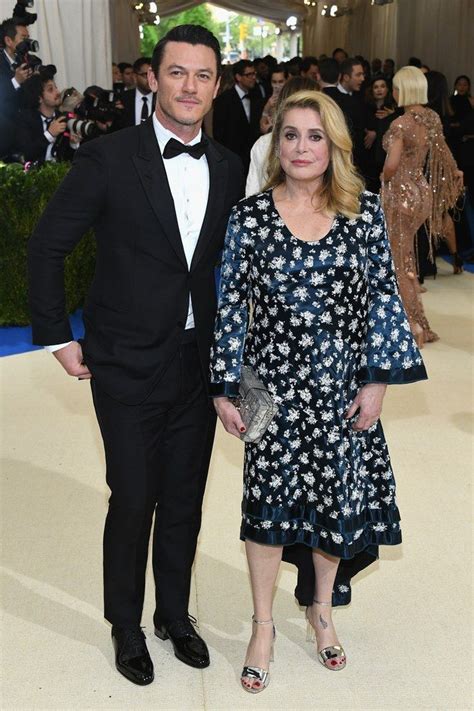 a man in a tuxedo standing next to a woman in a floral dress