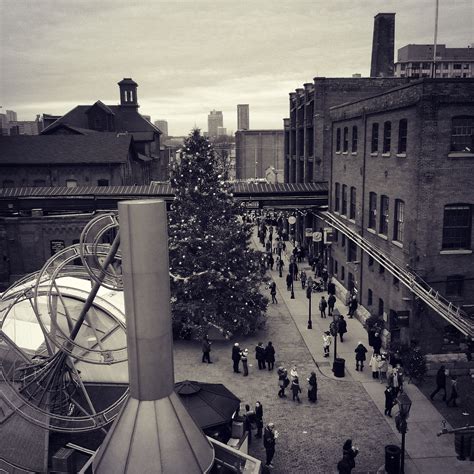 an aerial view of people walking around in the city with a christmas tree on top