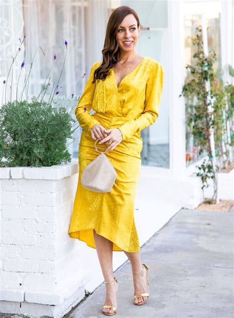 Sydne Style shows holiday party outfit ideas in yellow dress with gold accessories | Sydne Style