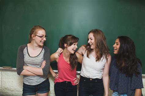 "Group High School Girls Laughing In Front Of Green Chalkboard" by Stocksy Contributor "Rob And ...