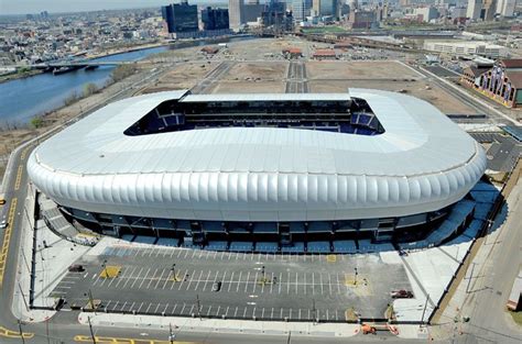 an aerial view of a stadium with the city in the background