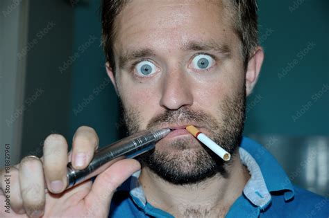 Man smoking e-cigarette, regular cigarette. Make funny face Stock Photo ...