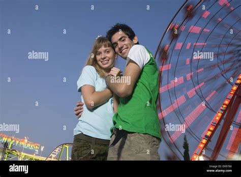 Teenage couple at Ferris wheel in amusement park Stock Photo - Alamy