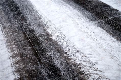 Tracks in Snow on Winter Asphalt Road - Background