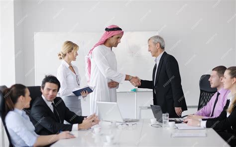 Premium Photo | Business meeting - Handsome young Arabic man presenting his ideas to colleagues ...