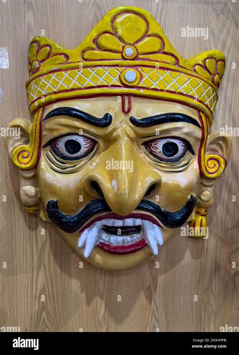 Handmade colorful tribal look of Ravan face mask souvenir hanging on plain black background ...