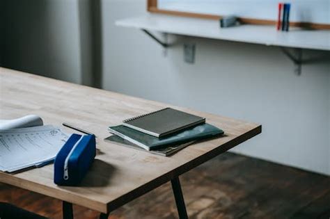 Desk with papers and textbooks in classroom · Free Stock Photo