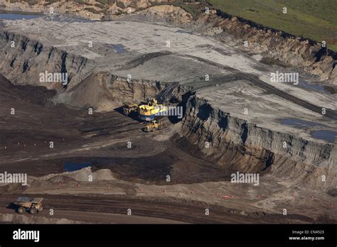 Oil sands mining at Suncor project near Fort McMurray, AB; Caterpillar 797 dumptrucks are filled ...