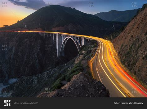 Sunset over Bixby Creek Bridge and car trail lights, Big Sur ...