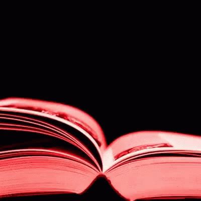 an open red book sitting on top of a black table next to a white cup