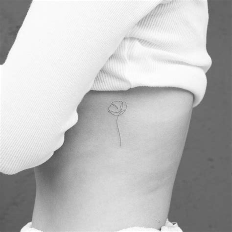 One line flower tattoo on the rib.