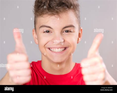 Close-up emotional portrait of caucasian teen boy wearing red t-shirt. Funny teenager making ...