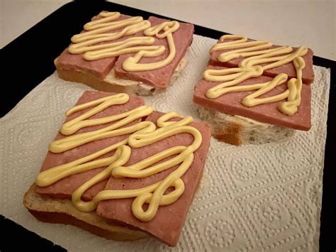 Spam and mayonnaise on defrosted white bread served on a cutting board. : depressionmeals