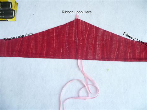 Sew along the curved line, making sure to catch both fabric layers and both ends of the ribbon ...
