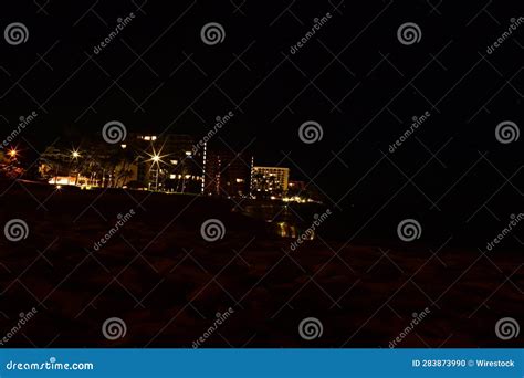 A Beach at Night with Lights on the Buildings in the Background Stock ...