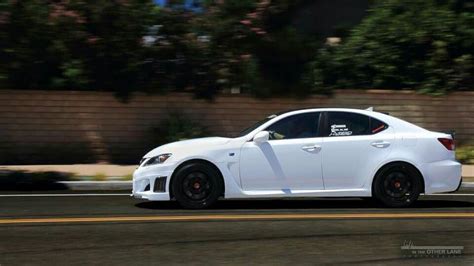 a white car driving down the road with black rims on it's tires